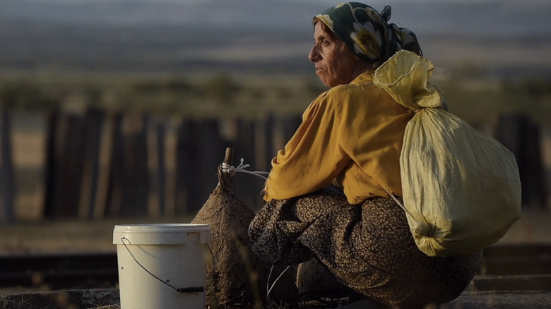 Hatidže Muratova sits with bucket