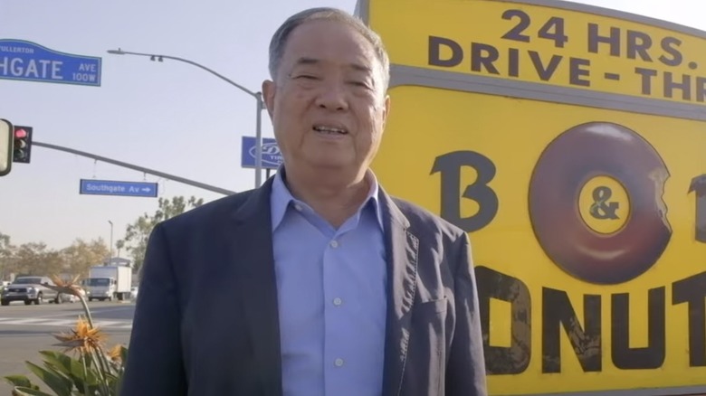 Ted Ngoy posing by sign