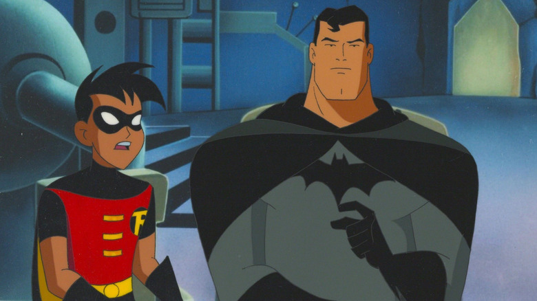 Superman dressed as Batman sits with Robin