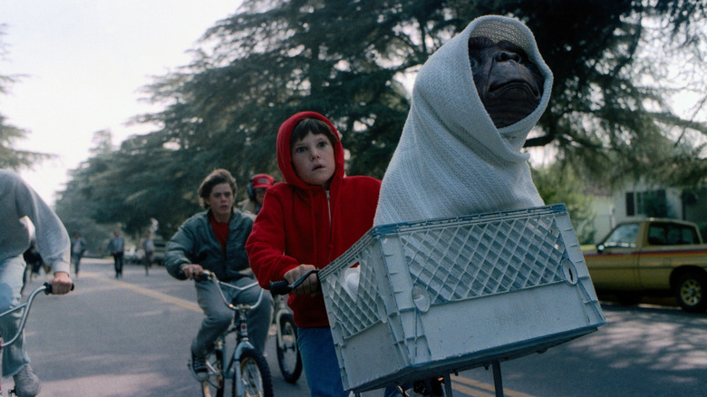 Elliott riding bike with ET in basket