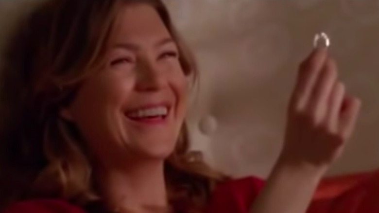 Meredith laughing and holding engagement ring