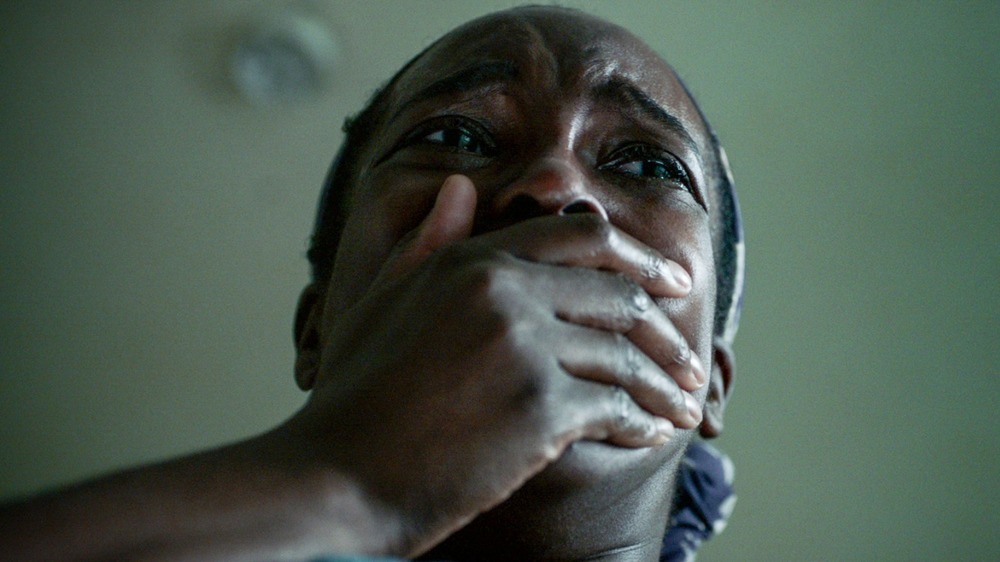 Actor Wunmi Mosaku covering her mouth in a scene from His House