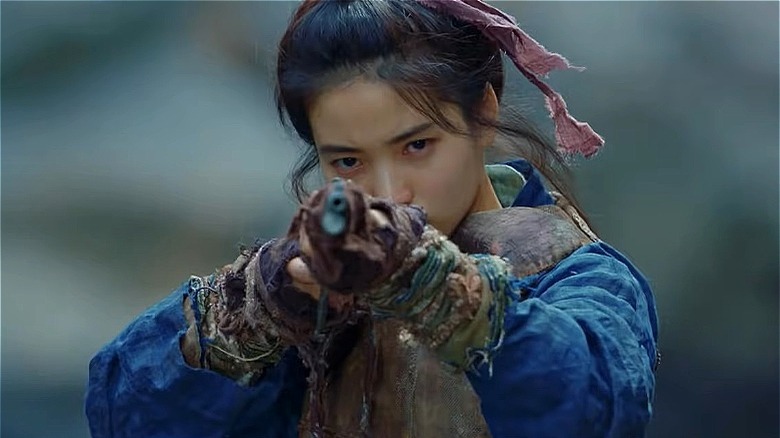 Tae-ri holding a gun