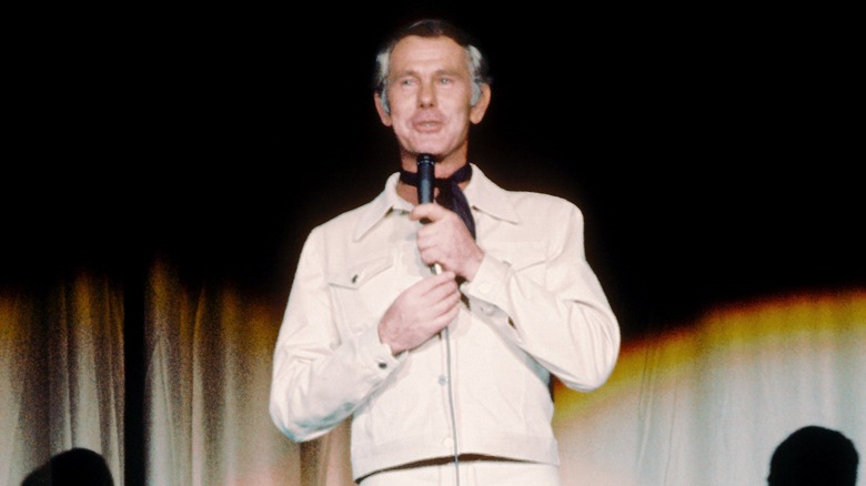 Johnny Carson speaking into microphone