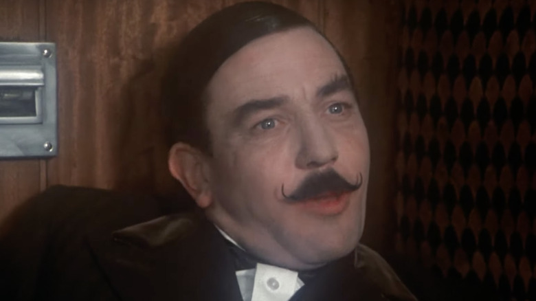 Hercule Poirot slouches in seat