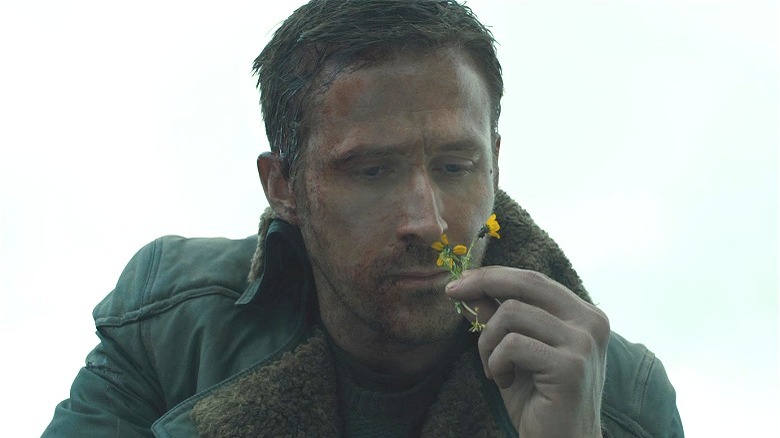 Ryan Gosling looking at a flower