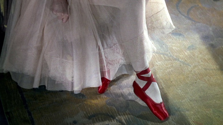 a ballerina wearing red shoes