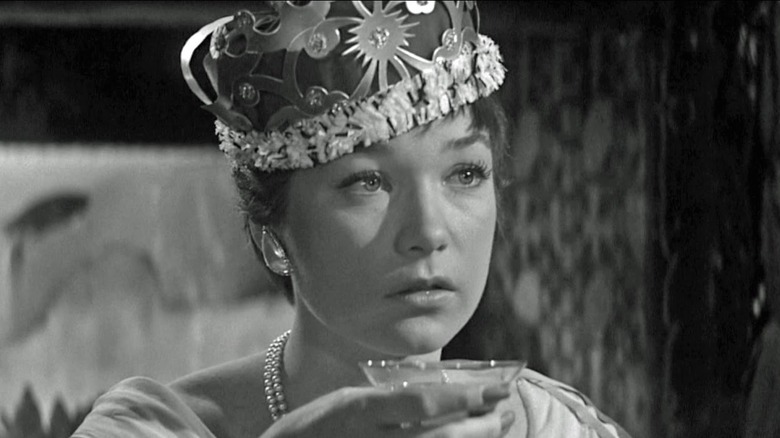 Shirley MacLaine wearing party hat with drink