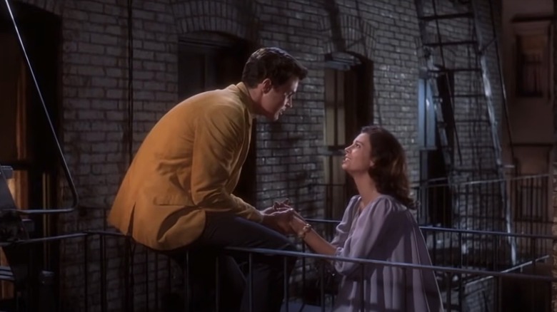 Tony and Maria holding hands on fire escape