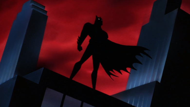 Silhouetted Batman standing on rooftop