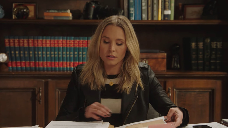 Veronica Mars leafing through documents