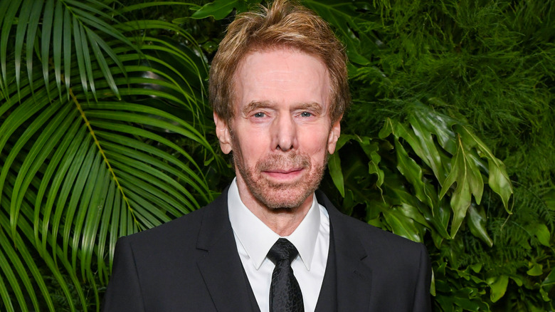 Jerry Bruckheimer stands near foliage