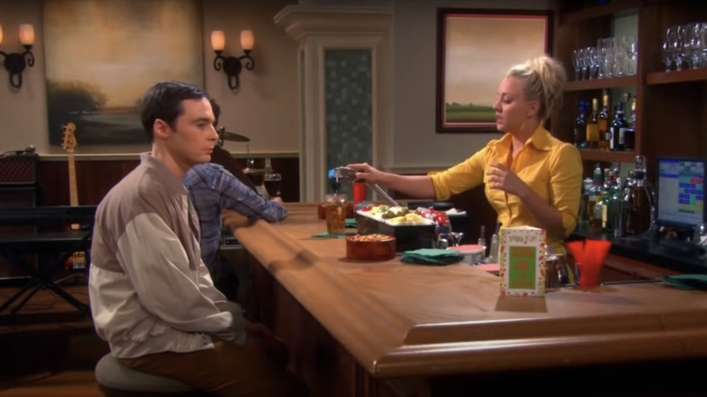 Penny serving Sheldon at bar