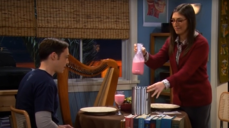 Amy serving Sheldon strawberry Nesquik