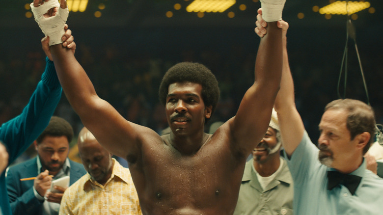 Khris Davis as George Foreman with arms raised in victory