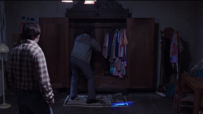 Ed Warren searching the wardrobe in The Conjuring