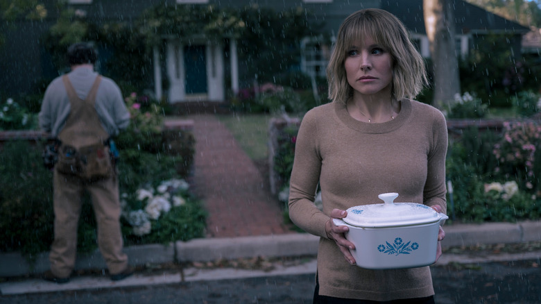 Anna holding casserole in rain