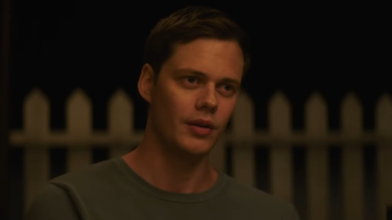 Bill Skarsgård in front of a fence