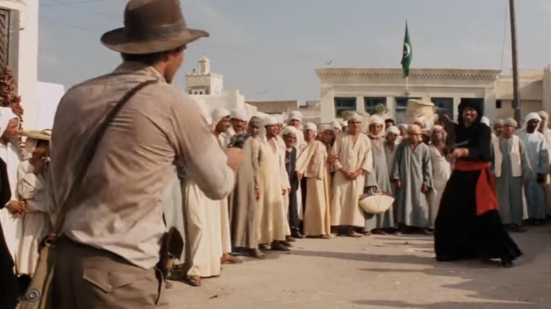 Indiana Jones shoots at a swordsman