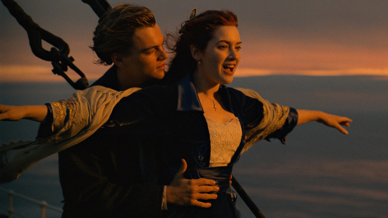 Jack holds Rose with arms out on front of Titanic