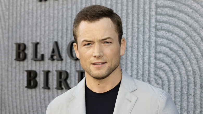 Taron Egerton on a red carpet posing