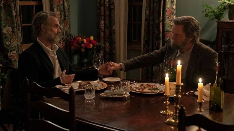 Frank and Bill holding hands over dinner