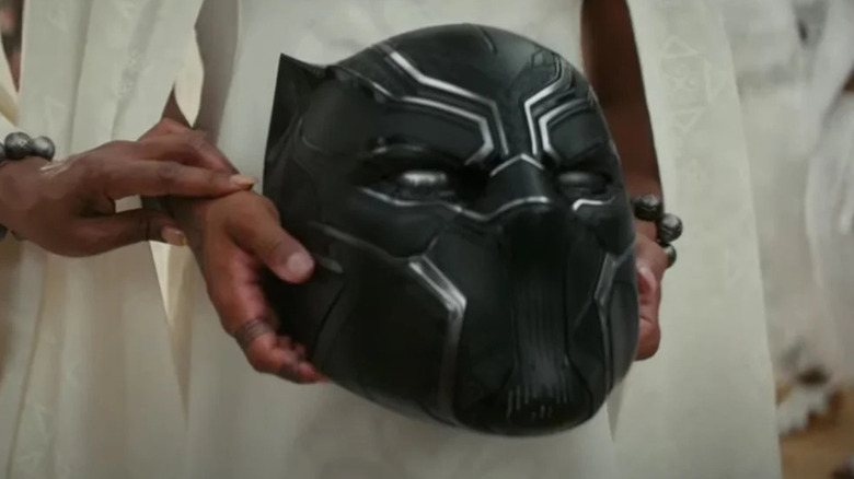 Shuri holding Black Panther helmet