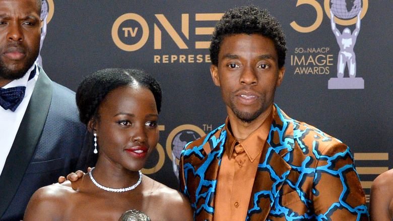 Chadwick Boseman and Lupita nyong'o standing beside one another at an awards ceremony