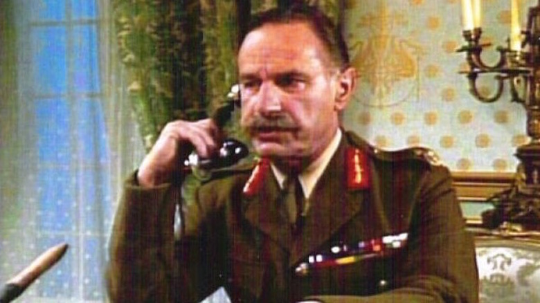 Geoffrey Palmer speaks into a telephone handset