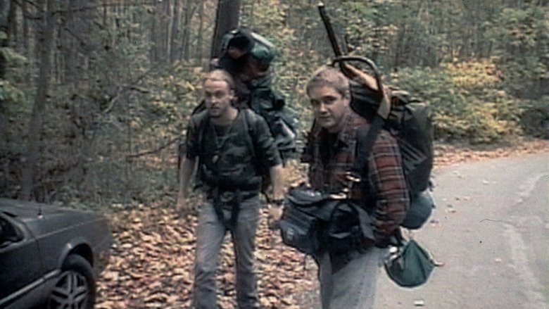 Josh and Mike with backpacks on hiking into the woods