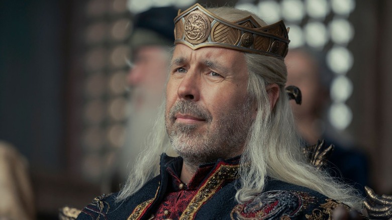 King Viserys sitting with crown