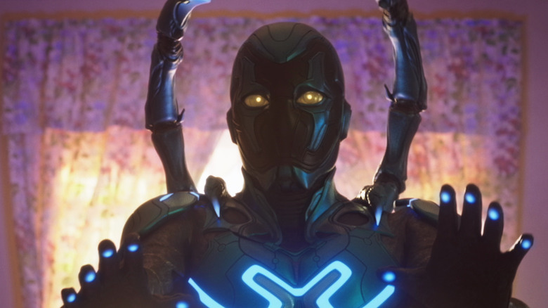 Blue Beetle in suit raising hands