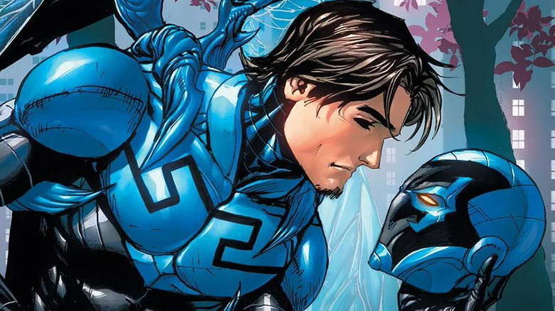 Jaime Reyes holding Blue Beetle helmet