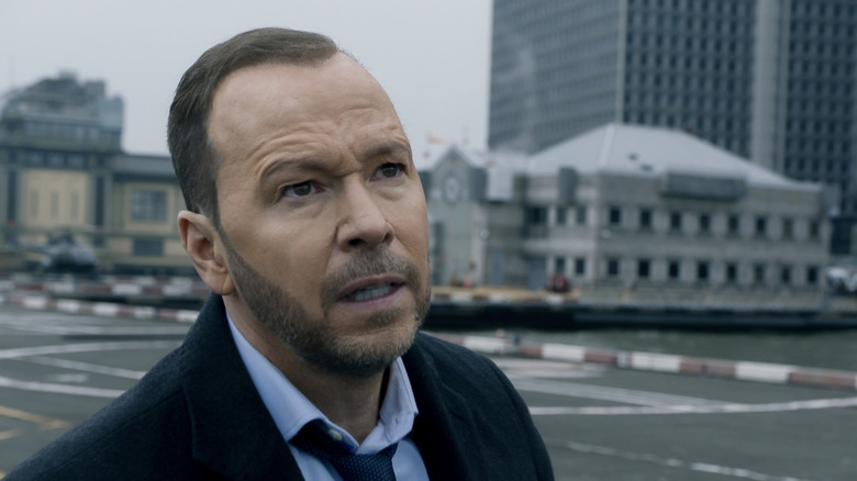 Danny Reagan with buildings behind him in "Blue Bloods"