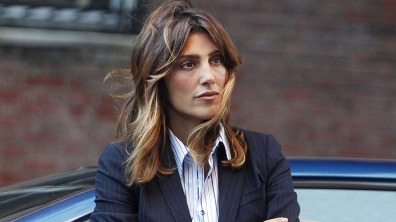 Jennifer Esposito leans on a car