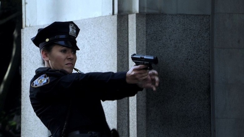 Officer Martin aims her sidearm