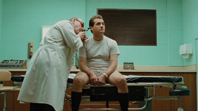 Larry Gopnik sitting on doctor's examination table