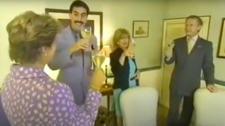 Borat toasting cheers with three fancy people