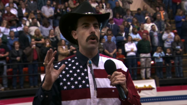 Borat speaking at rodeo dressed like a patriotic cowboy