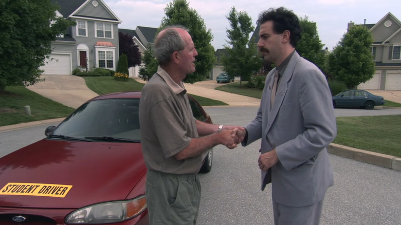 Borat shaking hands with driving instructor