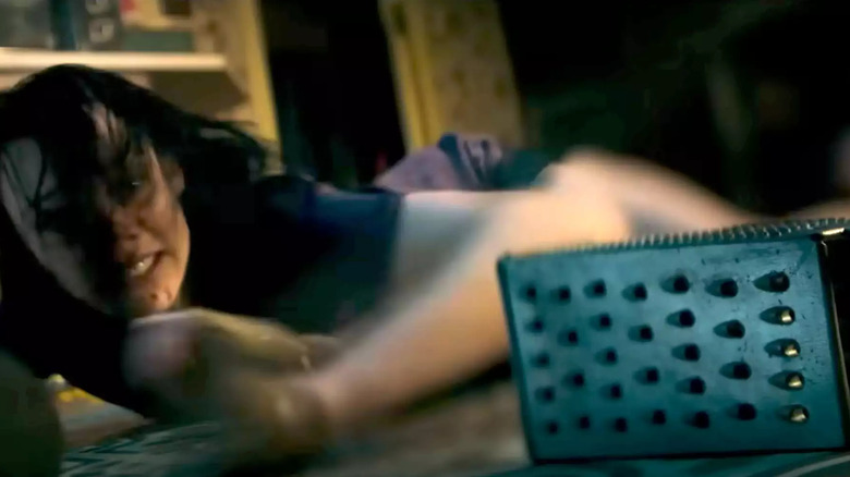 Woman lying on the floor with a cheese grater