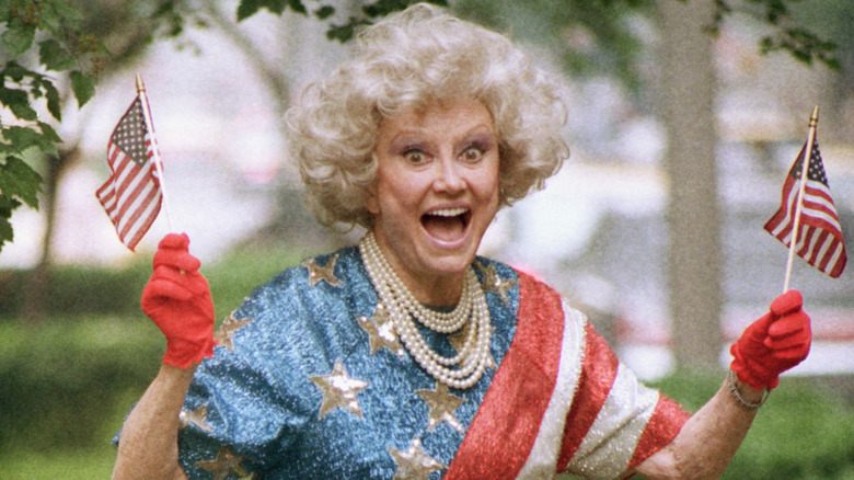 Phyllis Diller holding flags