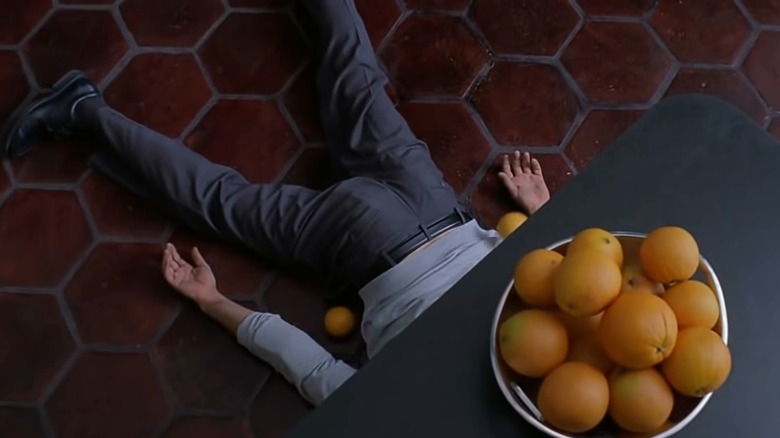 Ted lies on the floor surrounded by oranges