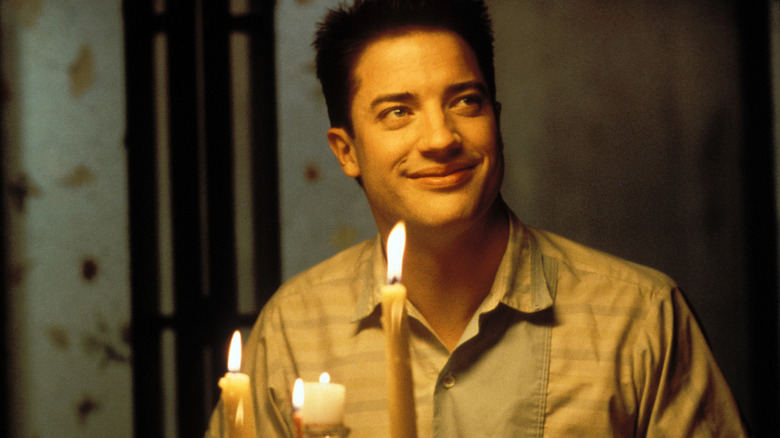 Man smiles next to birthday cake 