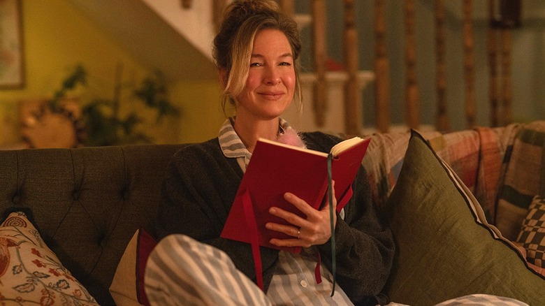 Bridget smiling at camera while holding red diary (2025)