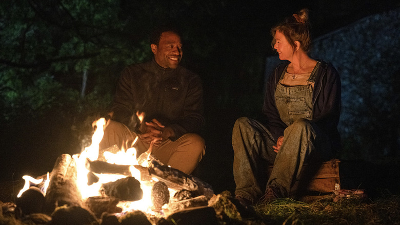 Bridget and Mr. Wallaker sitting by a fire laughing