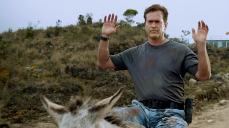 Bruce Campbell riding a donkey