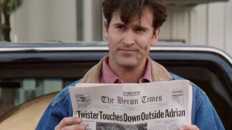 Bruce Campbell holding a newspaper