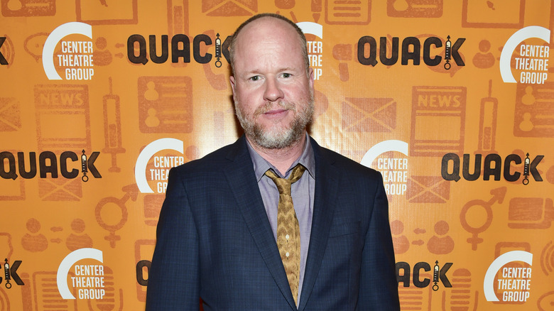 Joss Whedon poses for a photo at an event