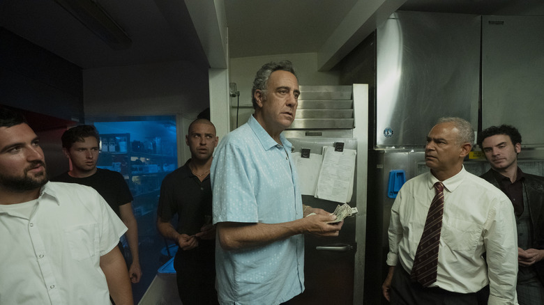 Roy holding money in restaurant kitchen